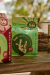 Packaging of Respé Haitian Coffee showing a green and red label with a graphic of a coffee bean, and text indicating medium roast.