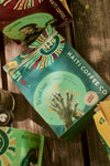 Packaging of TÈT āndi laye Haitian Coffee with a graphic of a hand and colorful design elements, indicating a light roast coffee blend.
