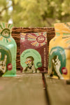 Packaging of Haiti Coffee's Kafe Dondon coffee bags displayed on a wooden surface with greenery in the background.